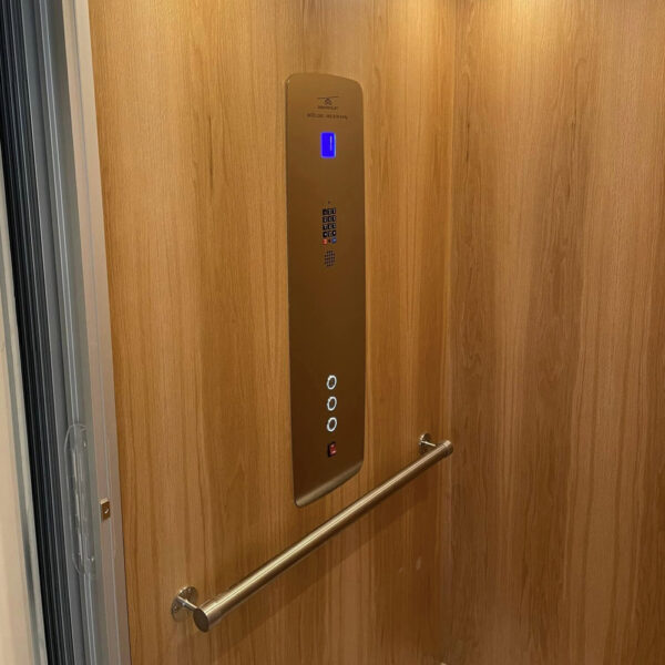 Crown Elevator New Jersey home elevator interior with wood paneling and bronze control panel