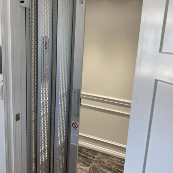 Crown Elevator installation home elevator with metal gate and white interior