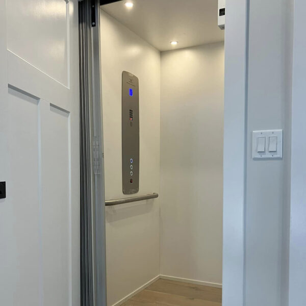 Crown Elevator New Jersey home elevator with white interior and stainless steel controls